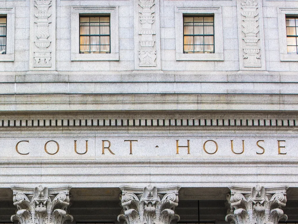 Stone courthouse facade with the words 'COURT HOUSE' carved above classical columns.